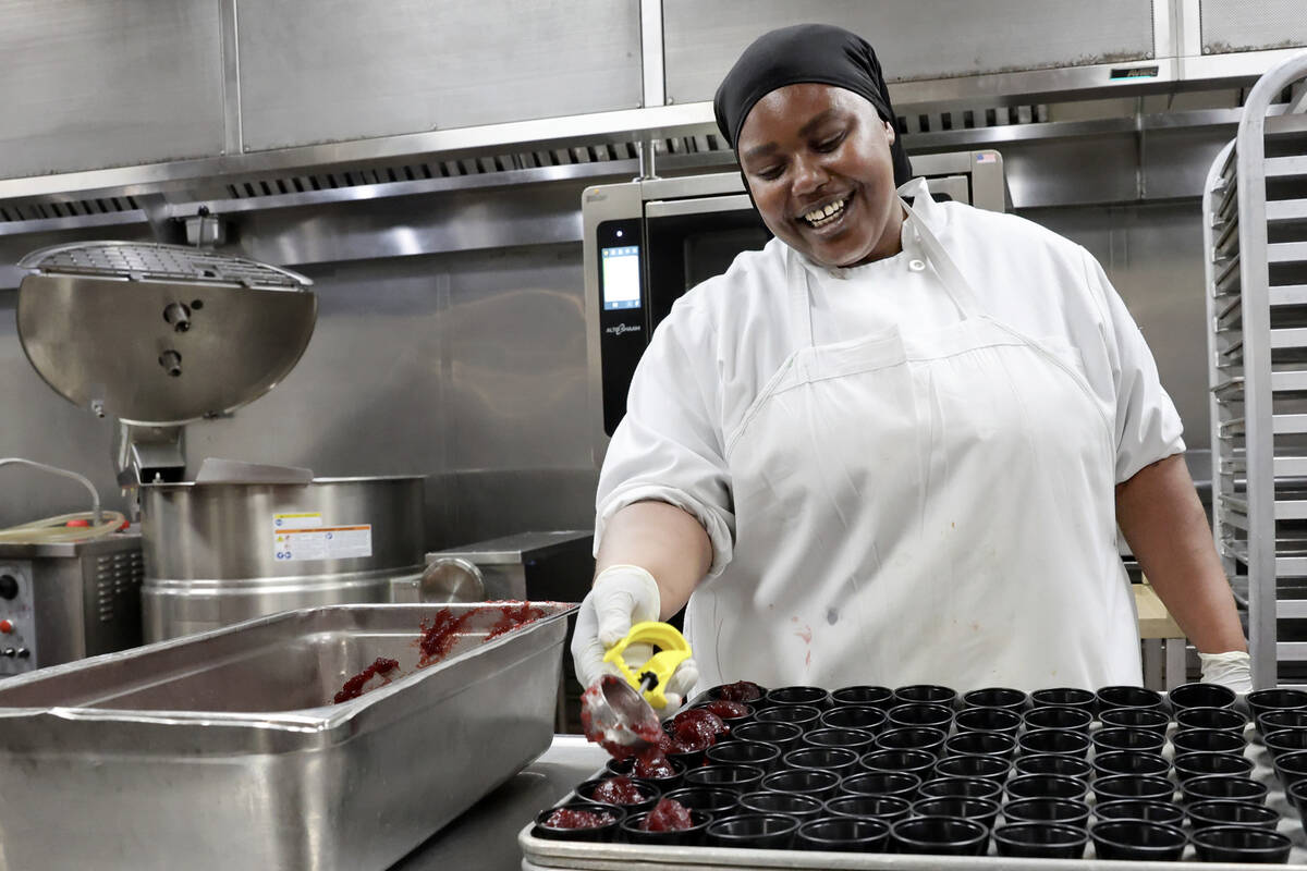 Production cook Coya Hill prepares servings of cranberry sauce for 700 Thanksgiving meals at Ca ...