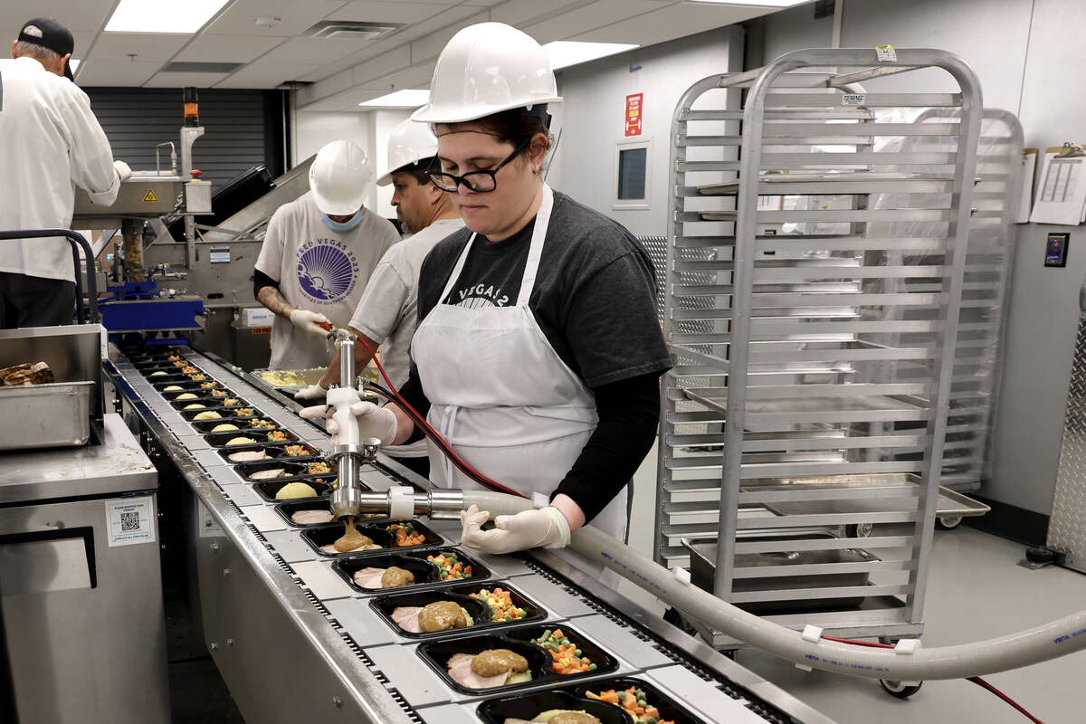 Workers make meals for the Meals on Wheels program at Catholic Charities of Southern Nevada in ...