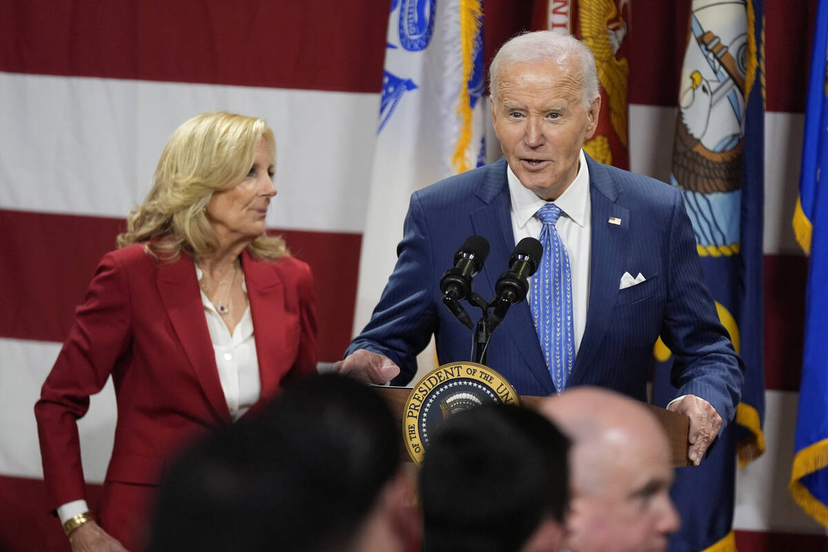 President Joe Biden speaks as first lady Jill Biden looks on at a Friendsgiving event with serv ...