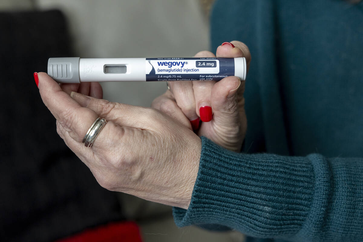 Donna Cooper holds up a dosage of Wegovy, a drug used for weight loss, at her home, March 1, 20 ...