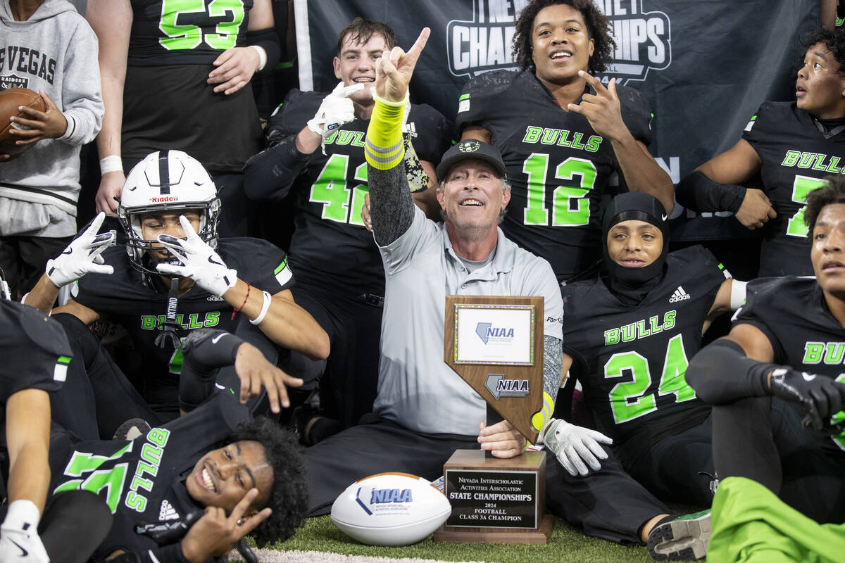 SLAM Academy Head Coach Mike Cofer celebrates with the team after winning the Class 3A football ...