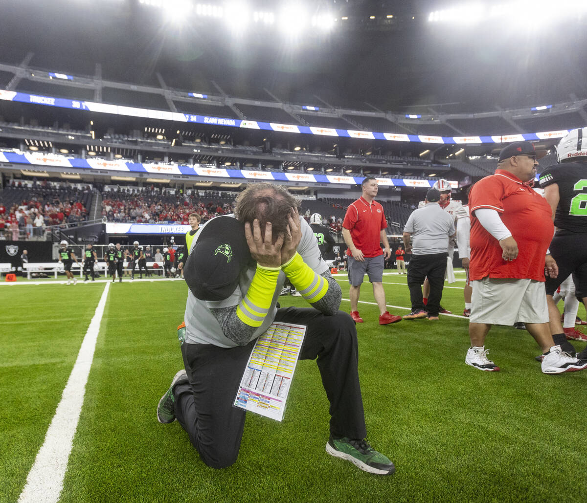 SLAM Academy Head Coach Mike Cofer takes a knee and buries his face in his hands after winning ...