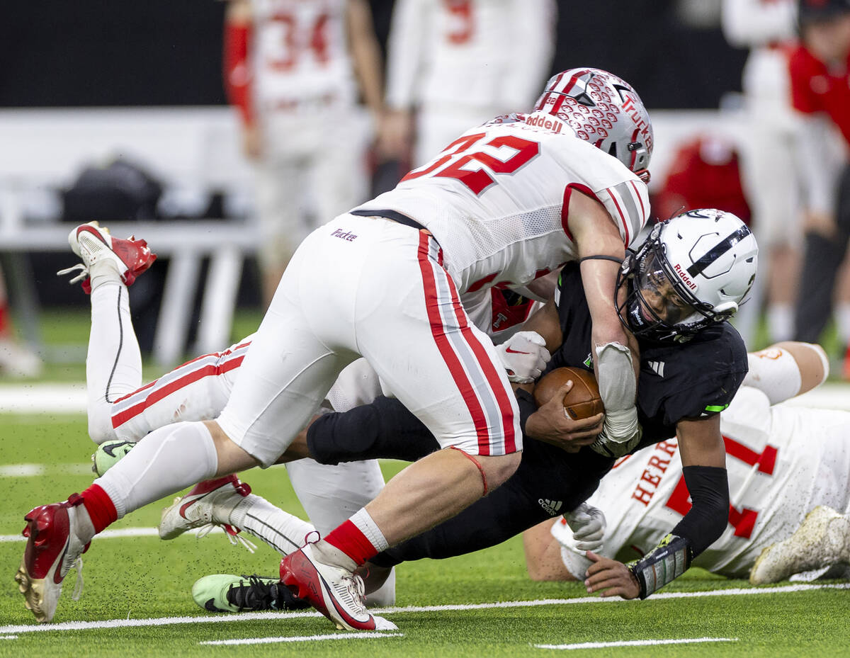 SLAM Academy junior Alaijah Young, right, is tackled by Truckee senior Colby Jitloff, left, dur ...