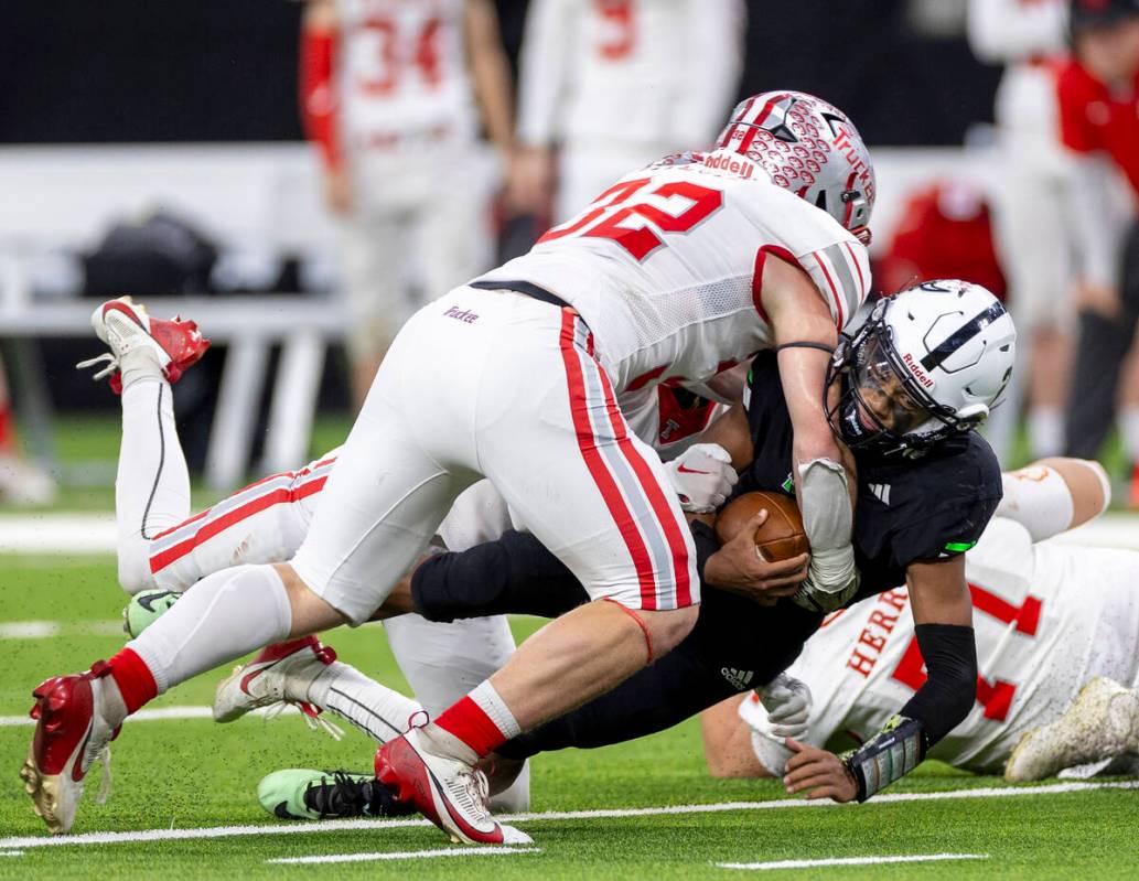 SLAM Academy junior Alaijah Young, right, is tackled by Truckee senior Colby Jitloff, left, dur ...