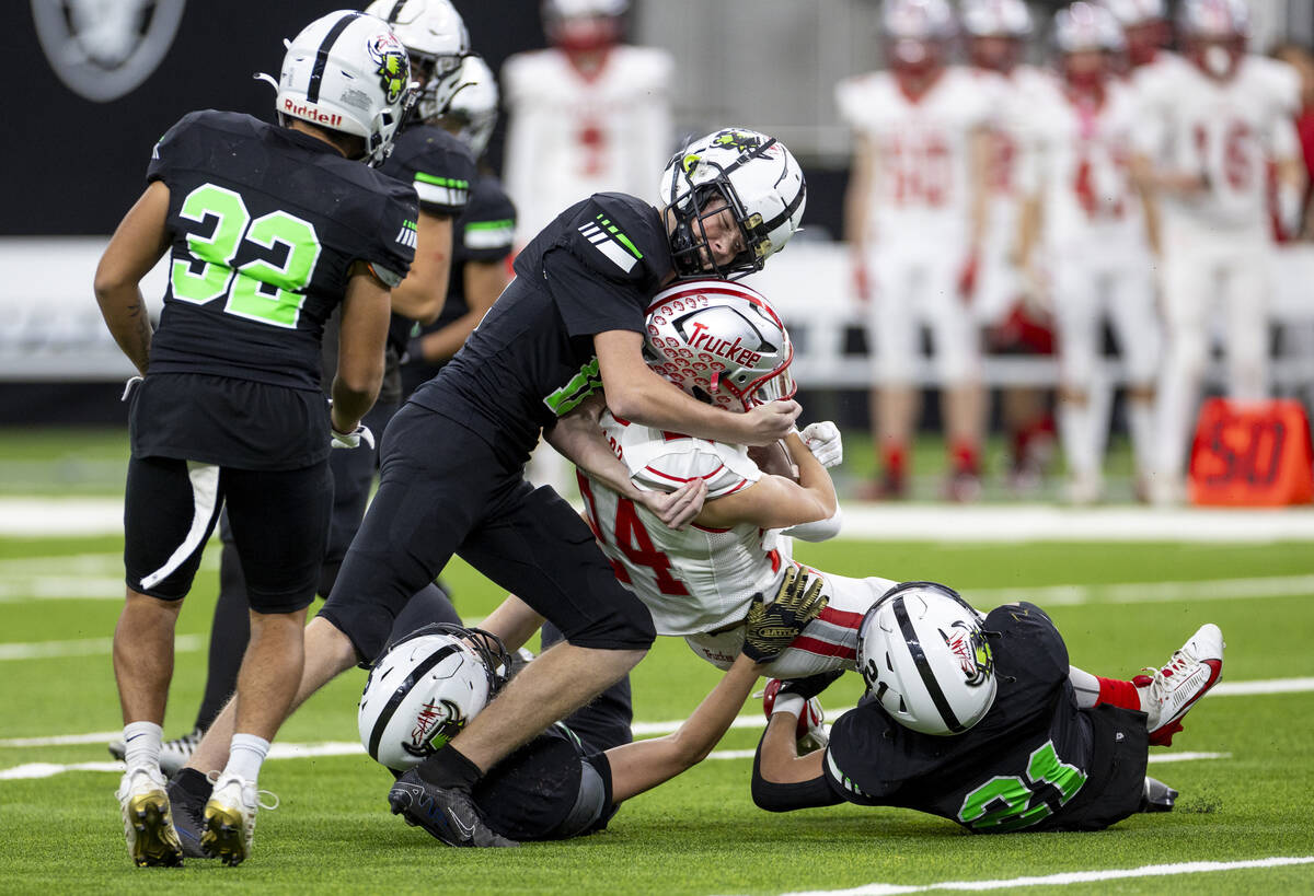 SLAM Academy junior Grant Ploetz, left, helps tackle Truckee sophomore Ivan Esparza, right, dur ...