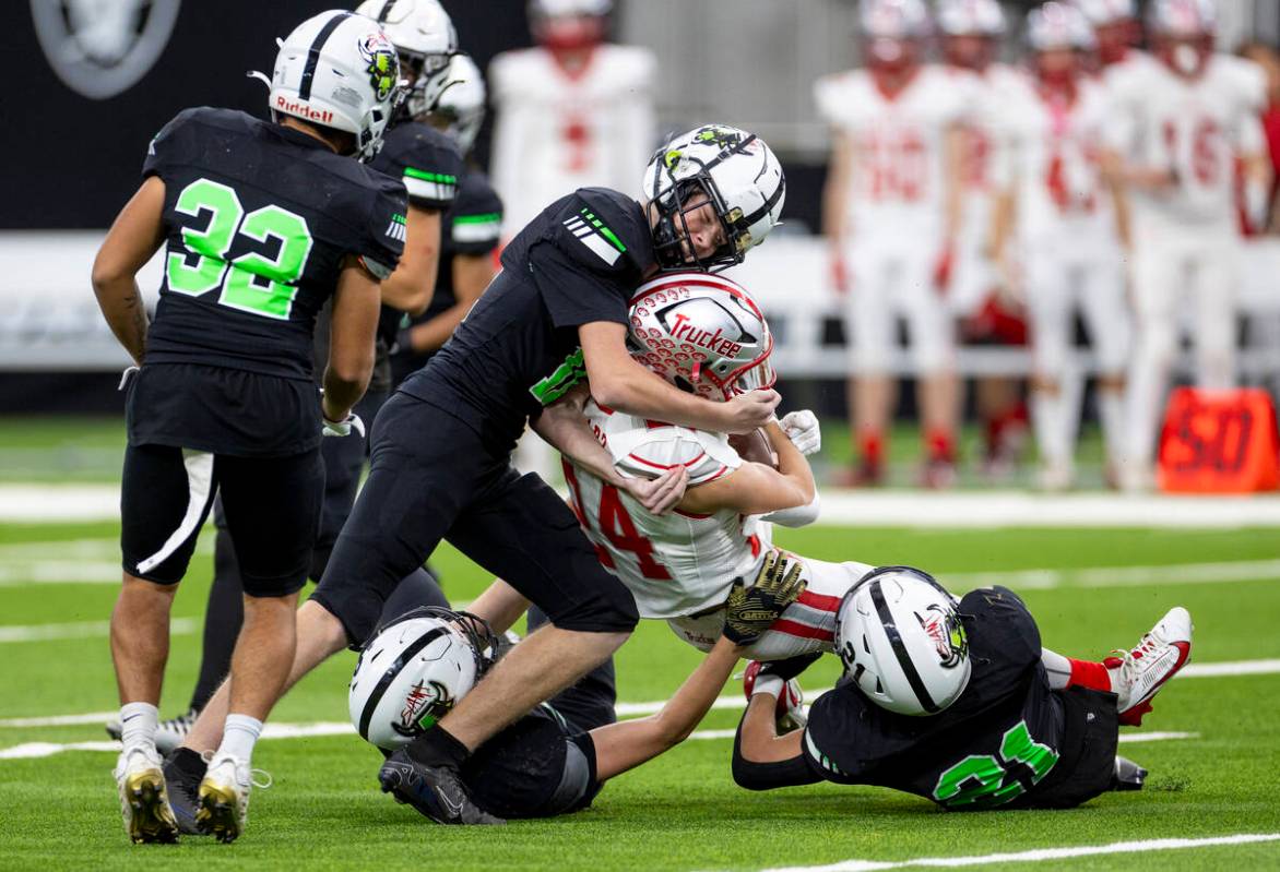 SLAM Academy junior Grant Ploetz, left, helps tackle Truckee sophomore Ivan Esparza, right, dur ...