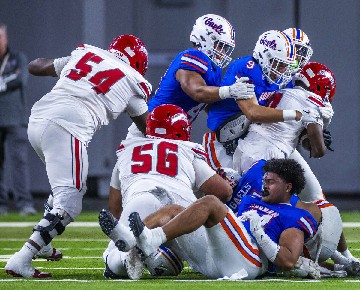 Arbor View running back Kamareion Bell (0) is stopped by Bishop Gorman linebacker Aloisio Malui ...