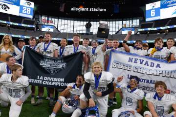 Pahranagat Valley players celebrate as they pose for a photo after topping Tonopah 28-6 to win ...