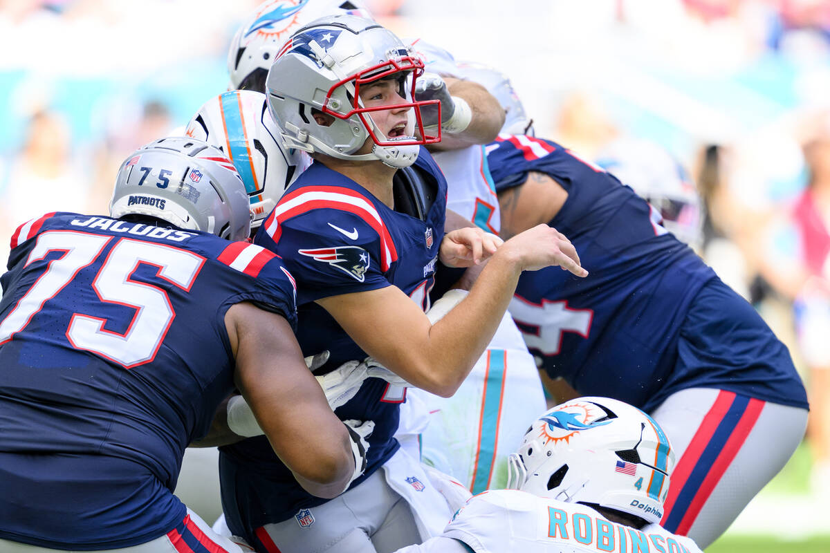 New England Patriots quarterback Drake Maye (10) reacts after throwing the ball and being hit b ...