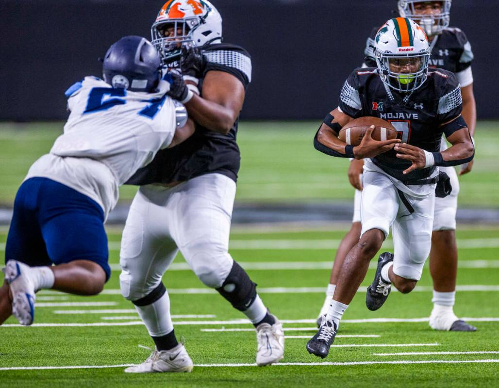 Mojave running back Antwan Hawkins (7) blast through the line against Canyon Springs during the ...