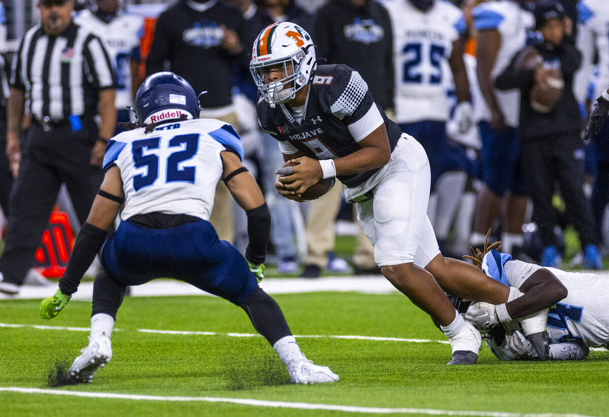 Mojave quarterback Mark Ames (9) hits a gap as Canyon Springs middle linebacker Jeremiah Richar ...