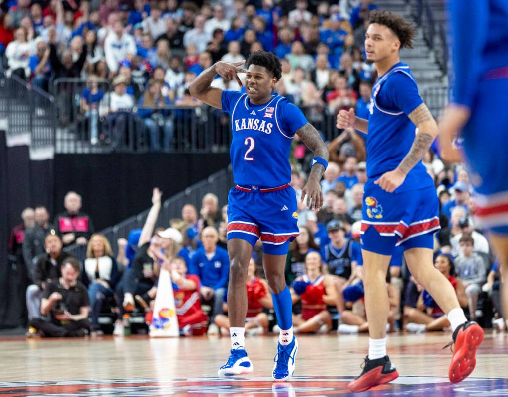 Kansas Jayhawks guard AJ Storr (2) holds three fingers up to his head after making a three-poin ...