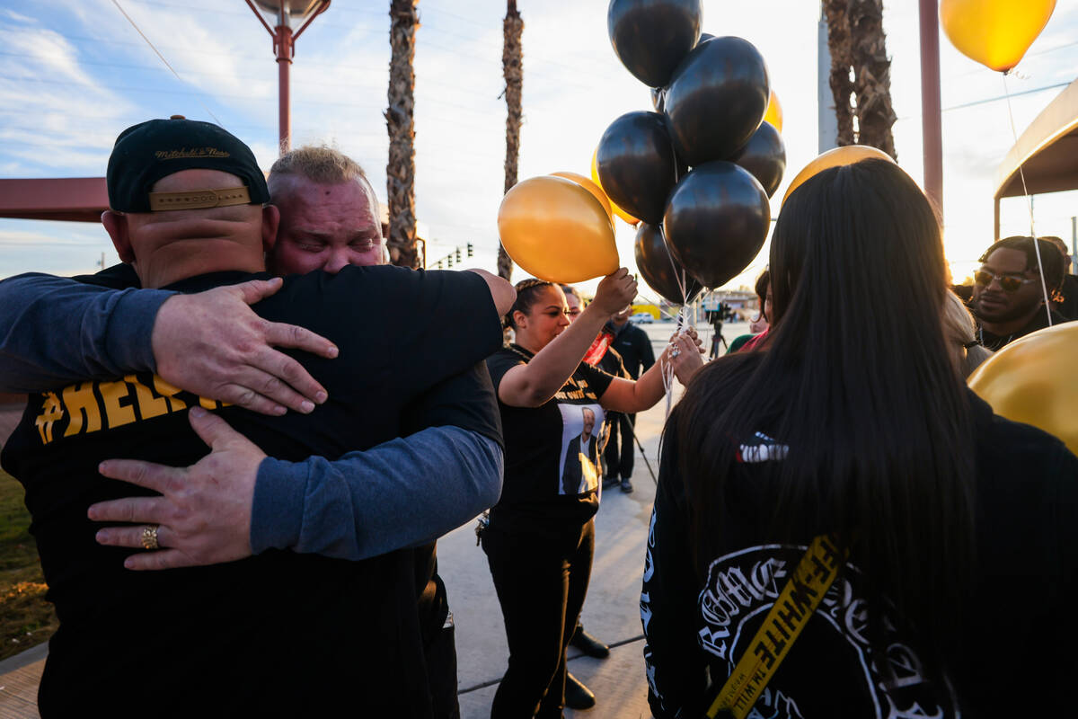 Lowell Pender, facing, hugs a fellow mourner during a vigil for his friend, Brandon Durham, who ...