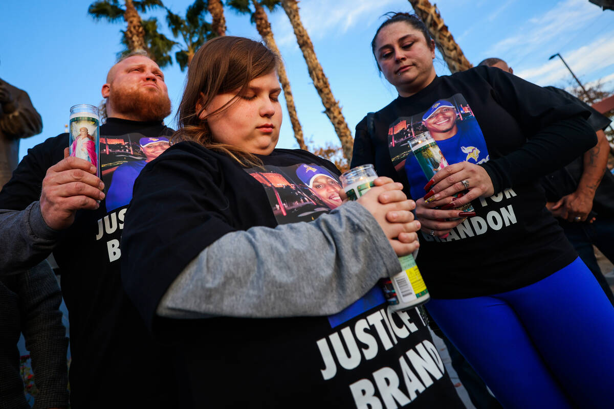 Elwood Pender, 12, closes his eyes for a moment of silence with his parents, Lowell, left, and ...