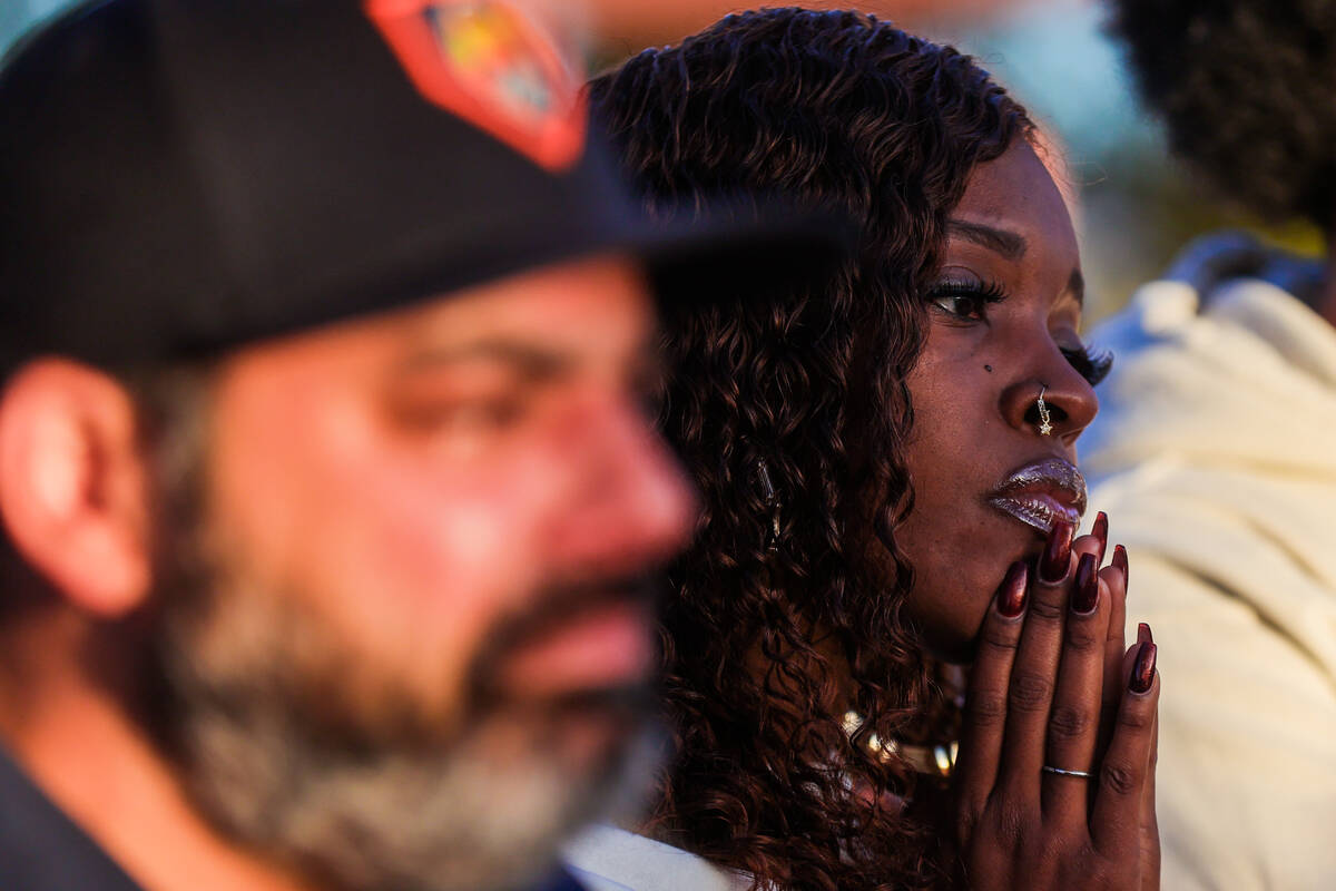 A mourner listens to a speech during a vigil for Brandon Durham, who was shot and killed in his ...