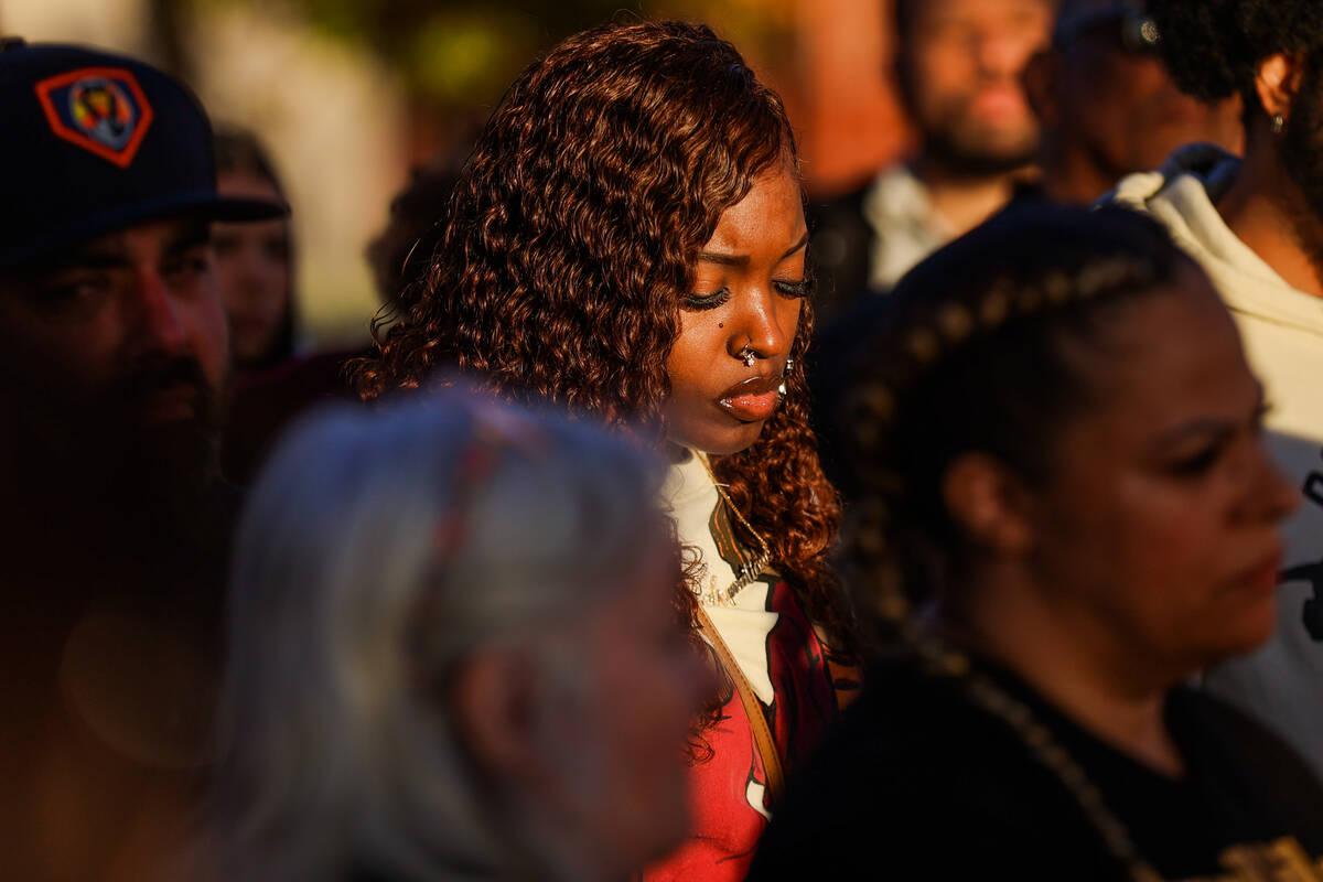 A mourner listens to a speech during a vigil for Brandon Durham, who was shot and killed in his ...