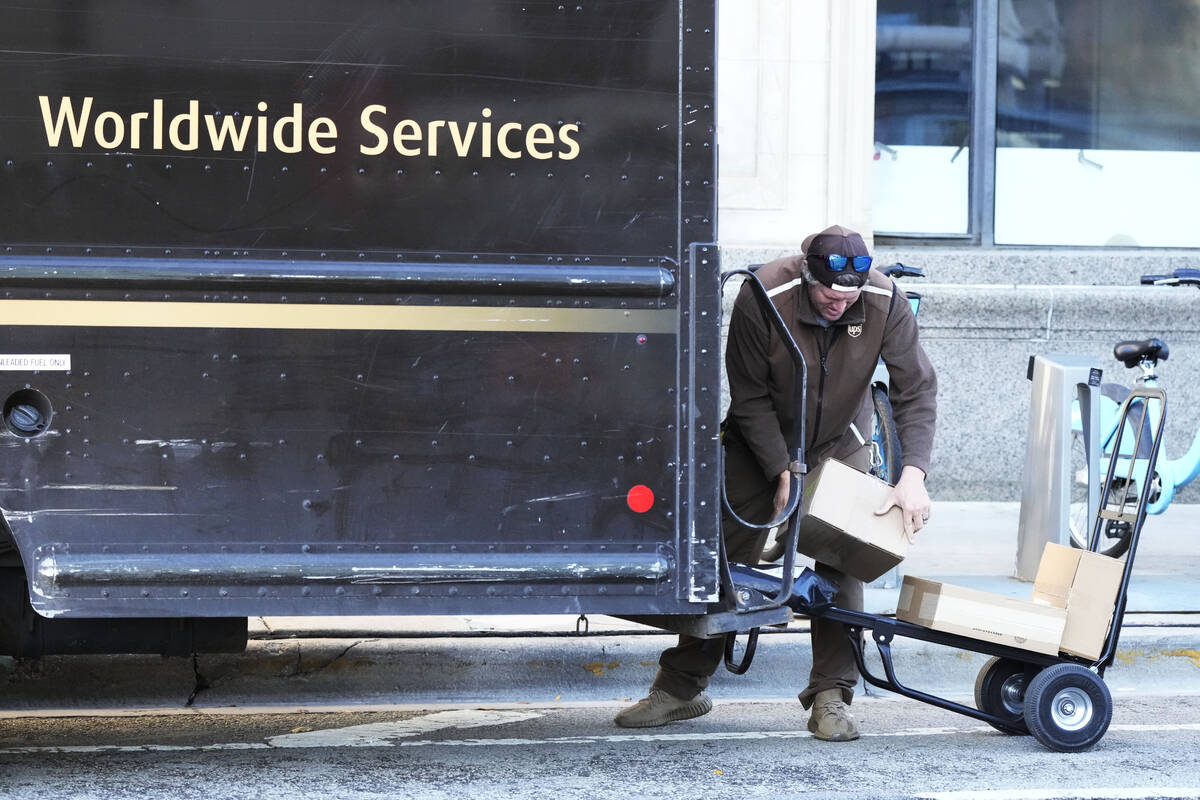 A UPS driver loads packages for delivery in Chicago, Wednesday, Nov. 20, 2024. (AP Photo/Nam Y. ...