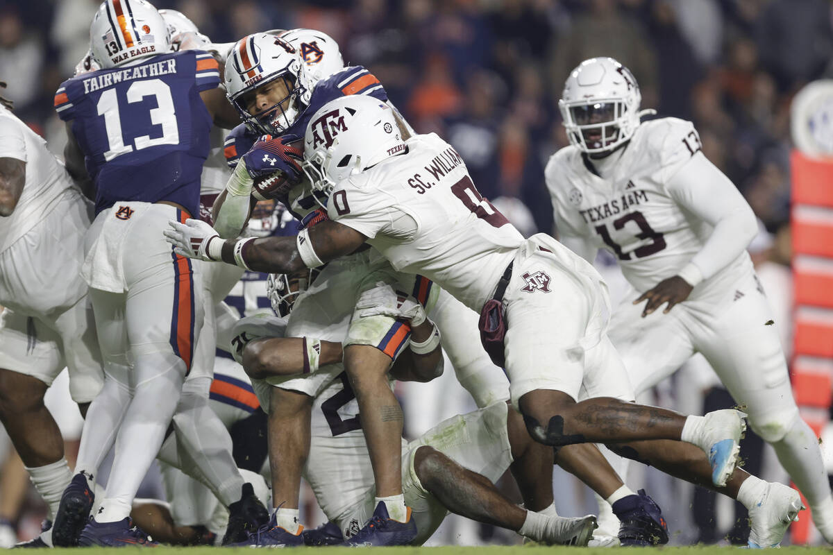 Auburn's Jarquez Hunter (27) is tackled by Texas A&M's Scooby Williams (0) during the secon ...