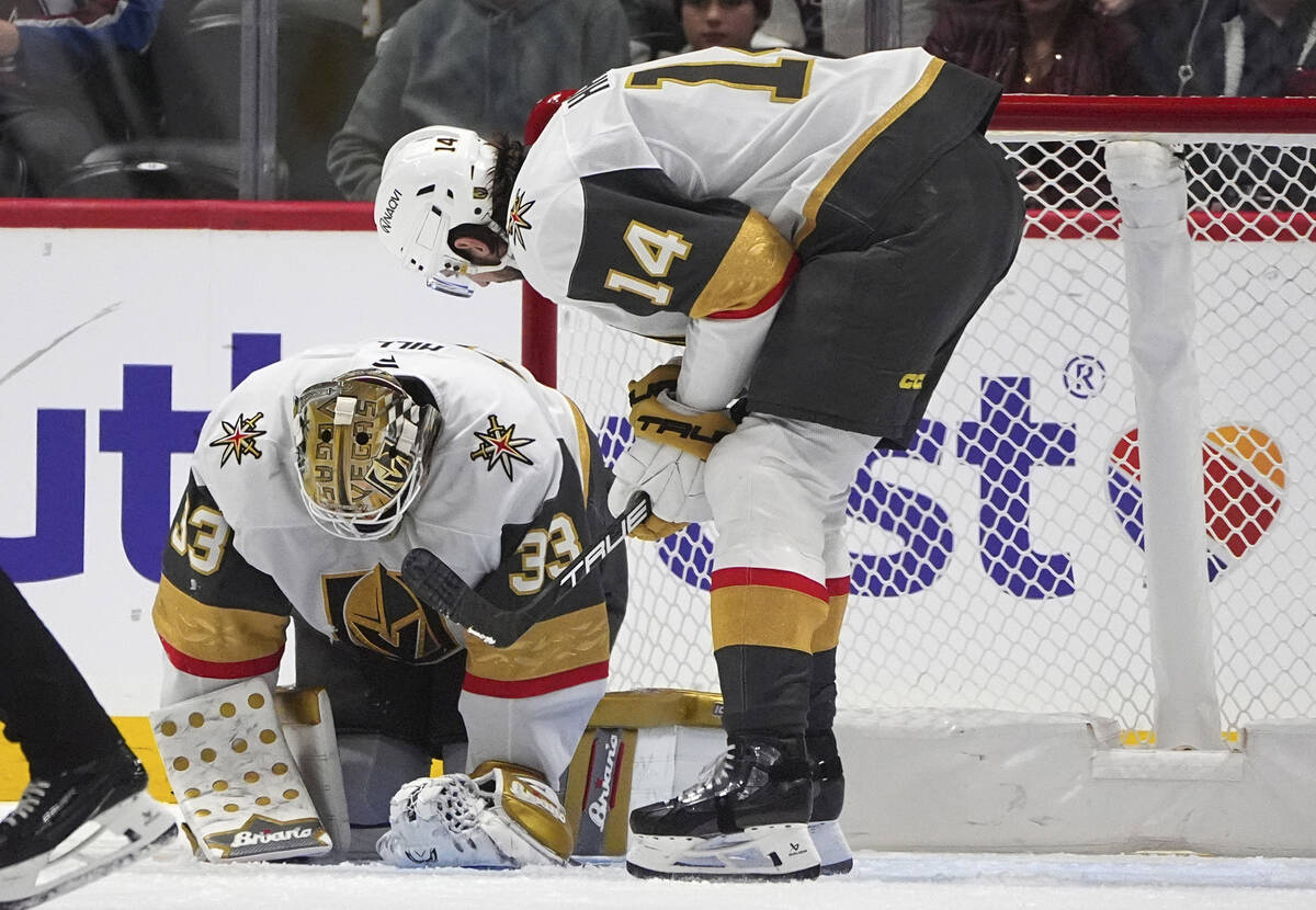 Vegas Golden Knights defenseman Nicolas Hague, right, checks on goaltender Adin Hill after he w ...