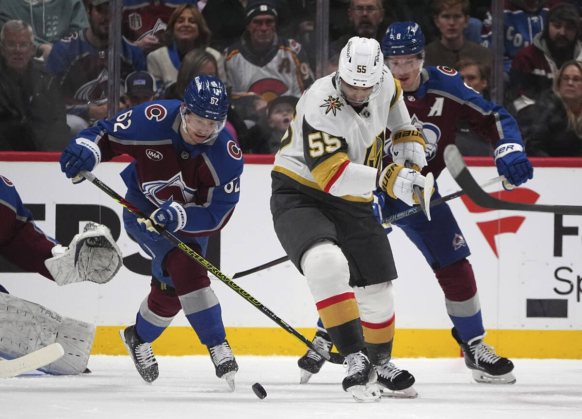 Vegas Golden Knights right wing Keegan Kolesar, center, struggles to control the puck as Colora ...