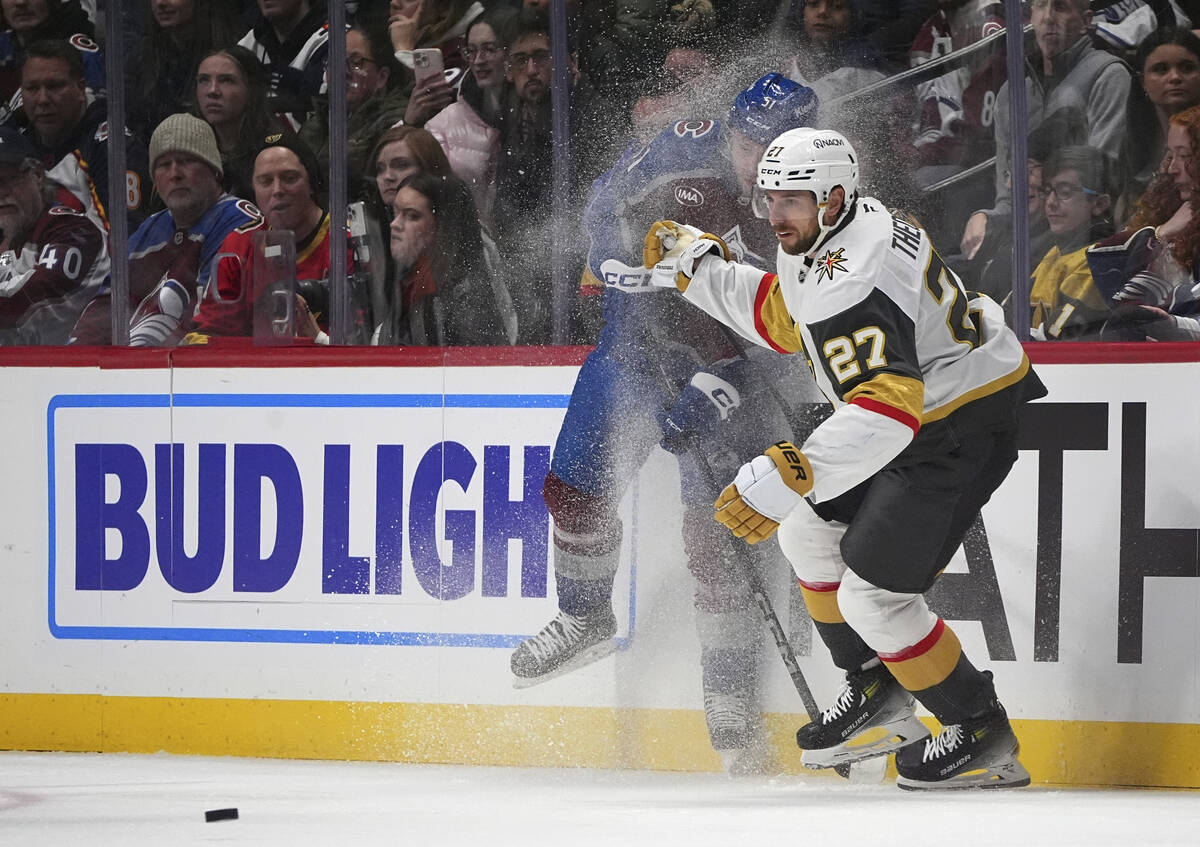 Vegas Golden Knights defenseman Shea Theodore, front, checks Colorado Avalanche right wing Niko ...