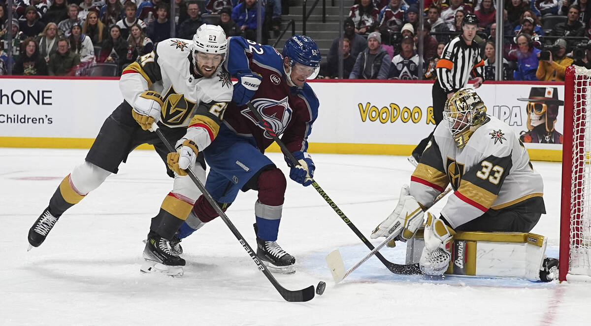 Colorado Avalanche left wing Artturi Lehkonen, center, fights for control of the puck between V ...