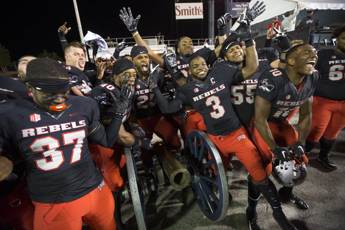 UNLV celebrates with the Fremont Cannon after defeating the Nevada Wolf Pack 34-29 following an ...