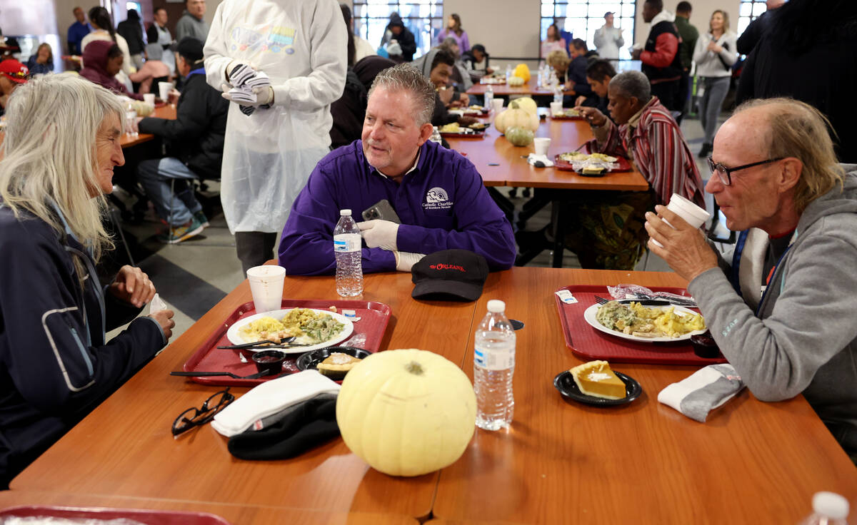 Deacon Tom Roberts, center, visits with married couple Lisa and David Wheeler, both 62, during ...