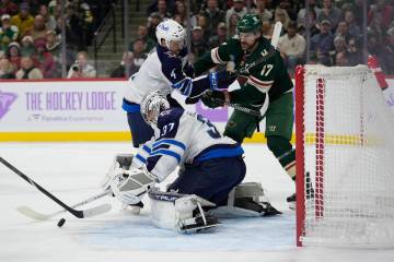 Winnipeg Jets goaltender Connor Hellebuyck (37) stops a shot during the first period of an NHL ...