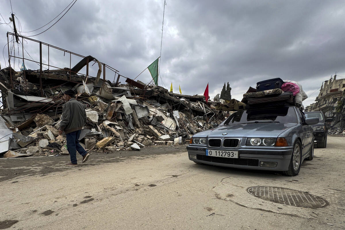 Displaced residents drive past destroyed buildings as they return to Nabatiyeh, southern Lebano ...