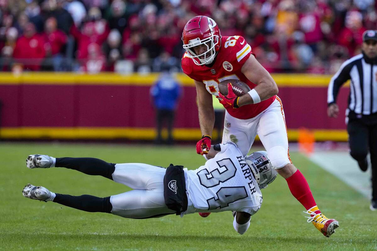 Kansas City Chiefs tight end Travis Kelce (87) is tackled by Las Vegas Raiders safety Thomas Ha ...