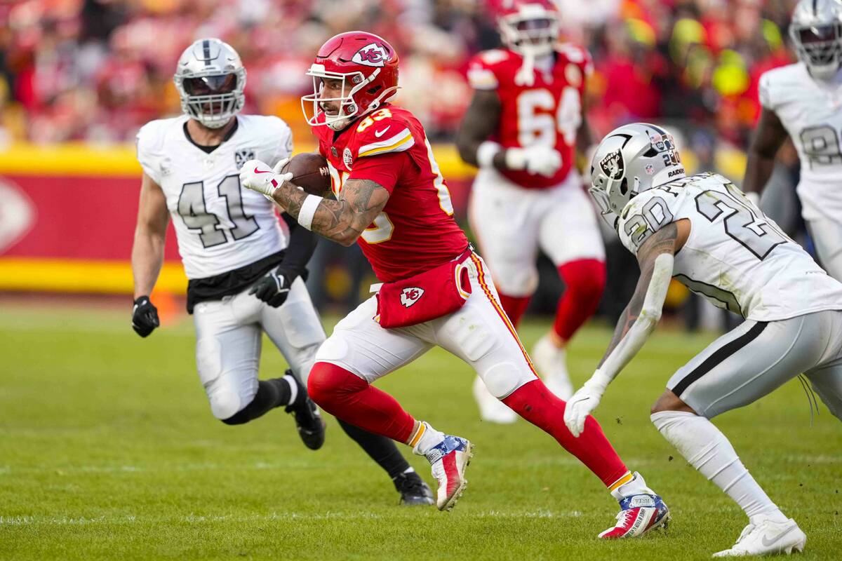 Kansas City Chiefs tight end Noah Gray (83) runs between Las Vegas Raiders linebacker Robert Sp ...