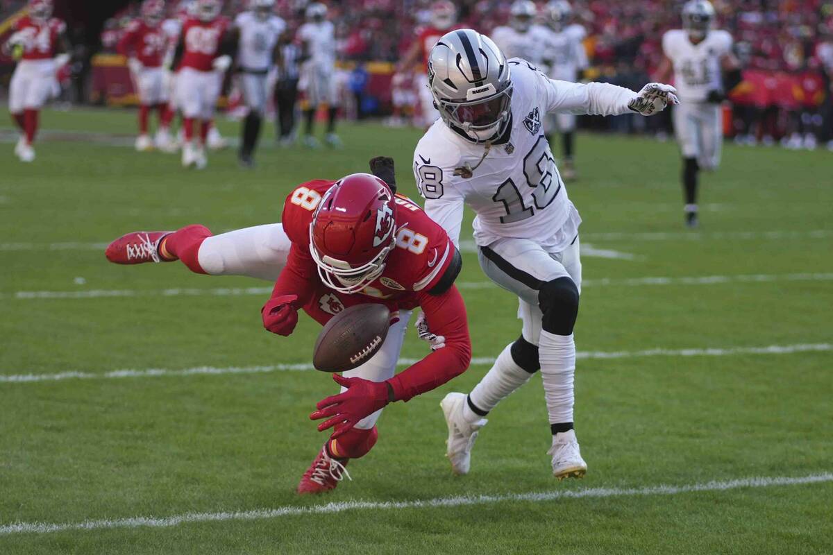 Las Vegas Raiders cornerback Jack Jones (18) breaks up a pass to Kansas City Chiefs wide receiv ...