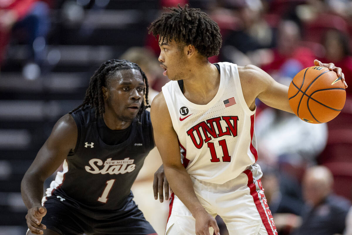 UNLV guard Dedan Thomas Jr. (11) looks to make a play against New Mexico State Aggies guard Gab ...