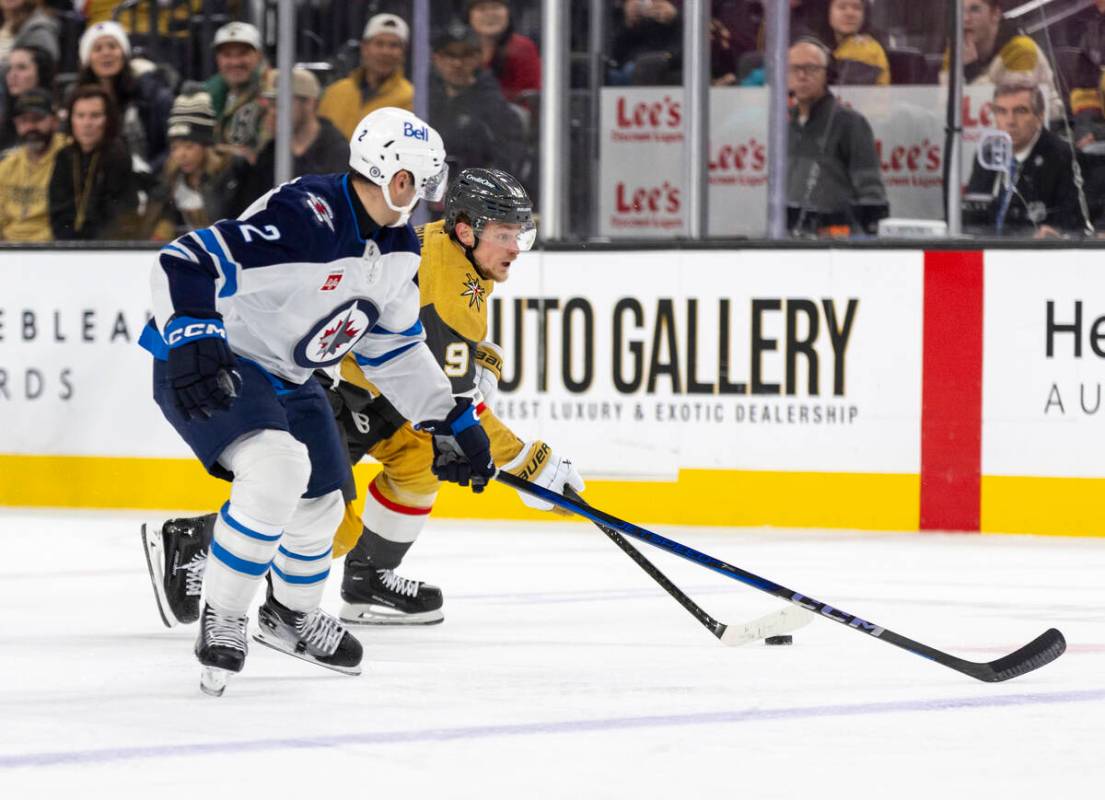 Golden Knights center Jack Eichel (9) attempts to pass Winnipeg Jets defenseman Dylan DeMelo (2 ...