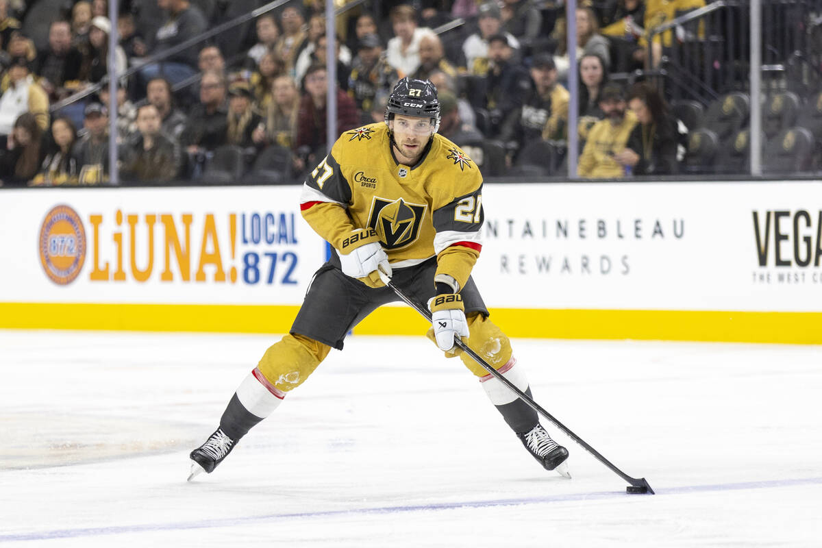 Golden Knights defenseman Shea Theodore (27) controls the puck during the NHL hockey game again ...