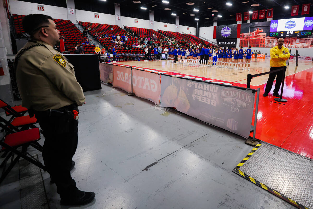 A police officer and security stand near the court as the San Jose State volleyball team is int ...