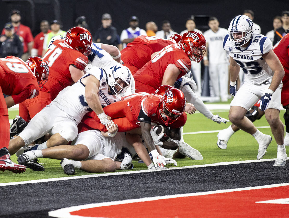 UNLV running back Jai'Den Thomas, center, dives to score a touchdown during the NCAA college fo ...