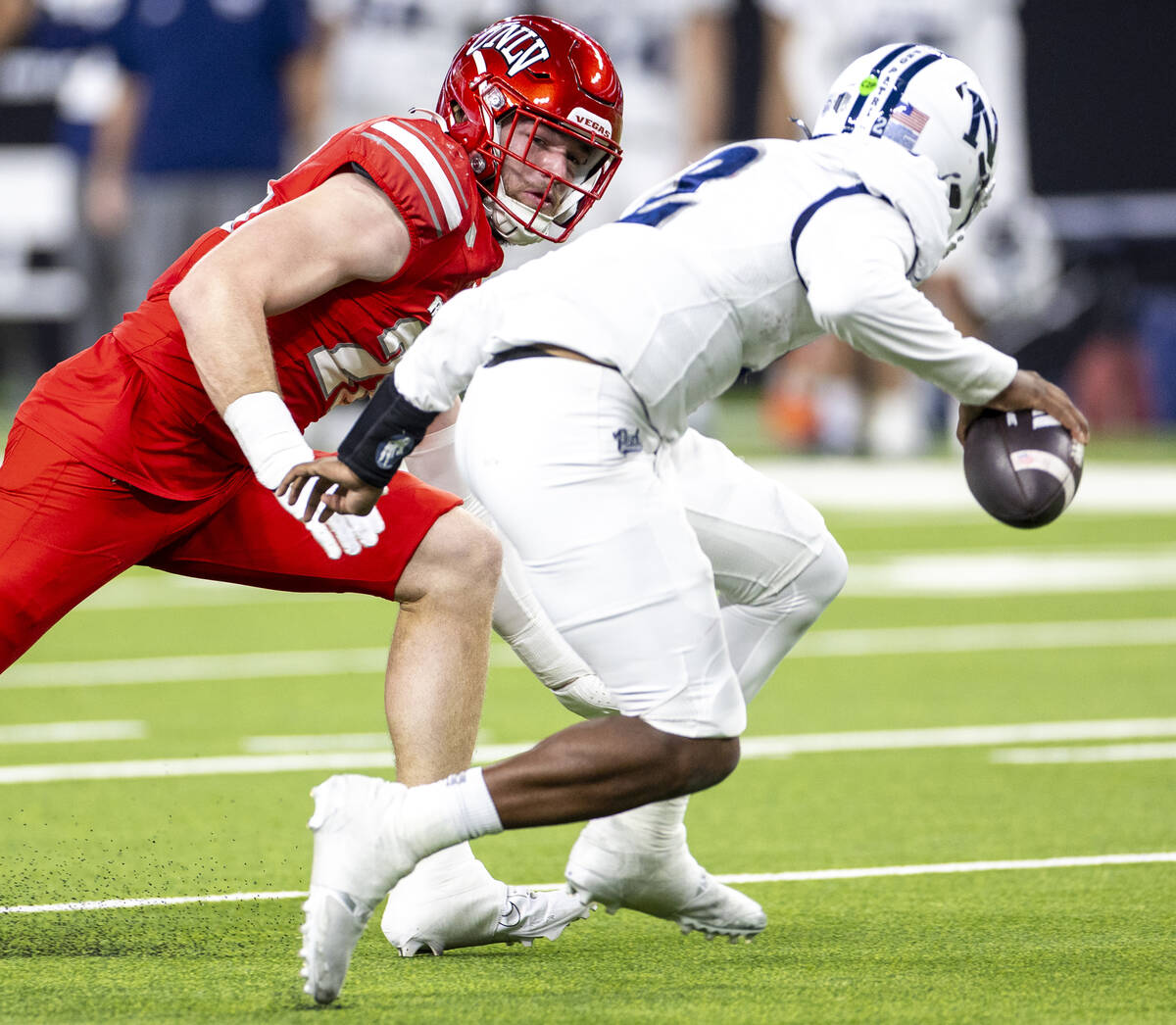 UNLV defensive lineman Fisher Camac, left, looks to tackle UNR quarterback Brendon Lewis (2) du ...