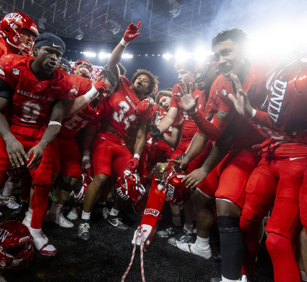 UNLV players dance with the Fremont Cannon after winning the NCAA college football game against ...