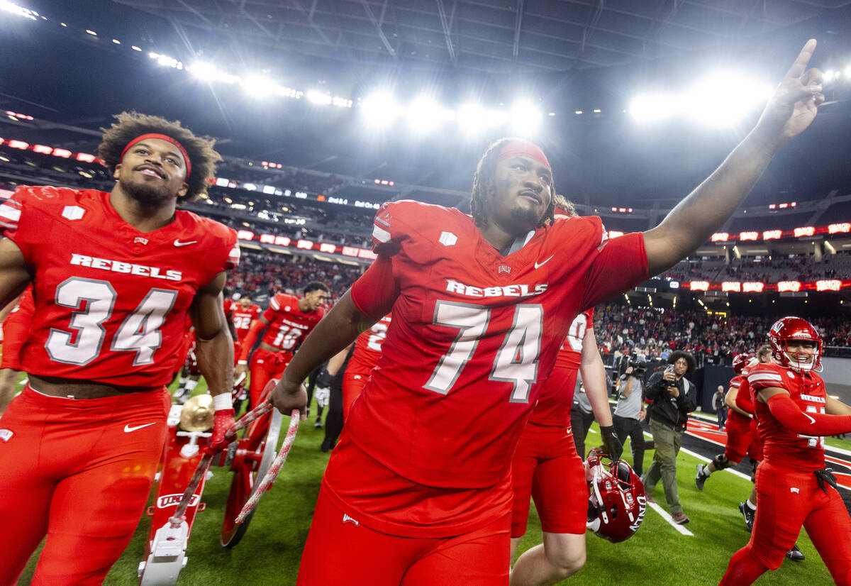 UNLV offensive lineman Jalen St. John (74) and UNLV linebacker Tyray O'Dell (34) wheel the Frem ...