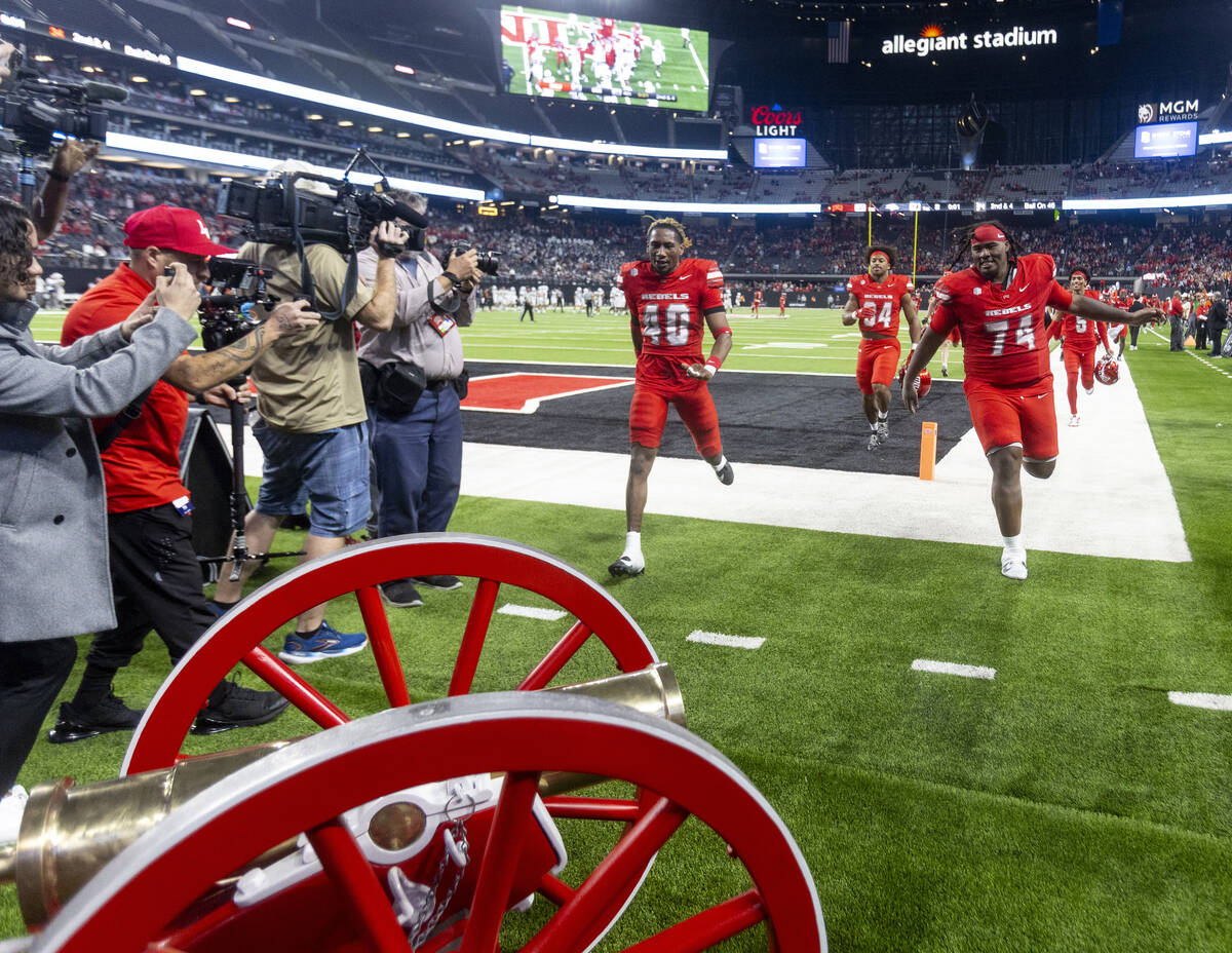 UNLV players run to the Fremont Cannon after winning the NCAA college football game against UNR ...