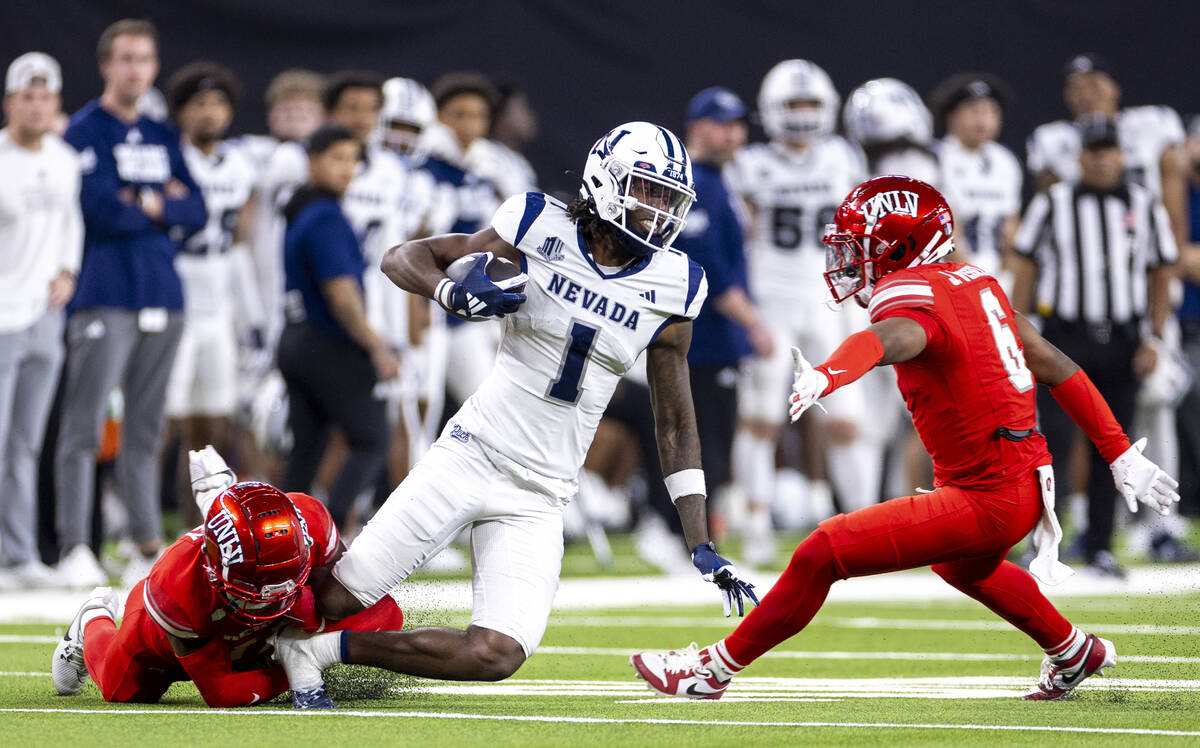 UNR wide receiver Jaden Smith (1) is tackled by UNLV defensive back La'Vario Wiley, left, durin ...