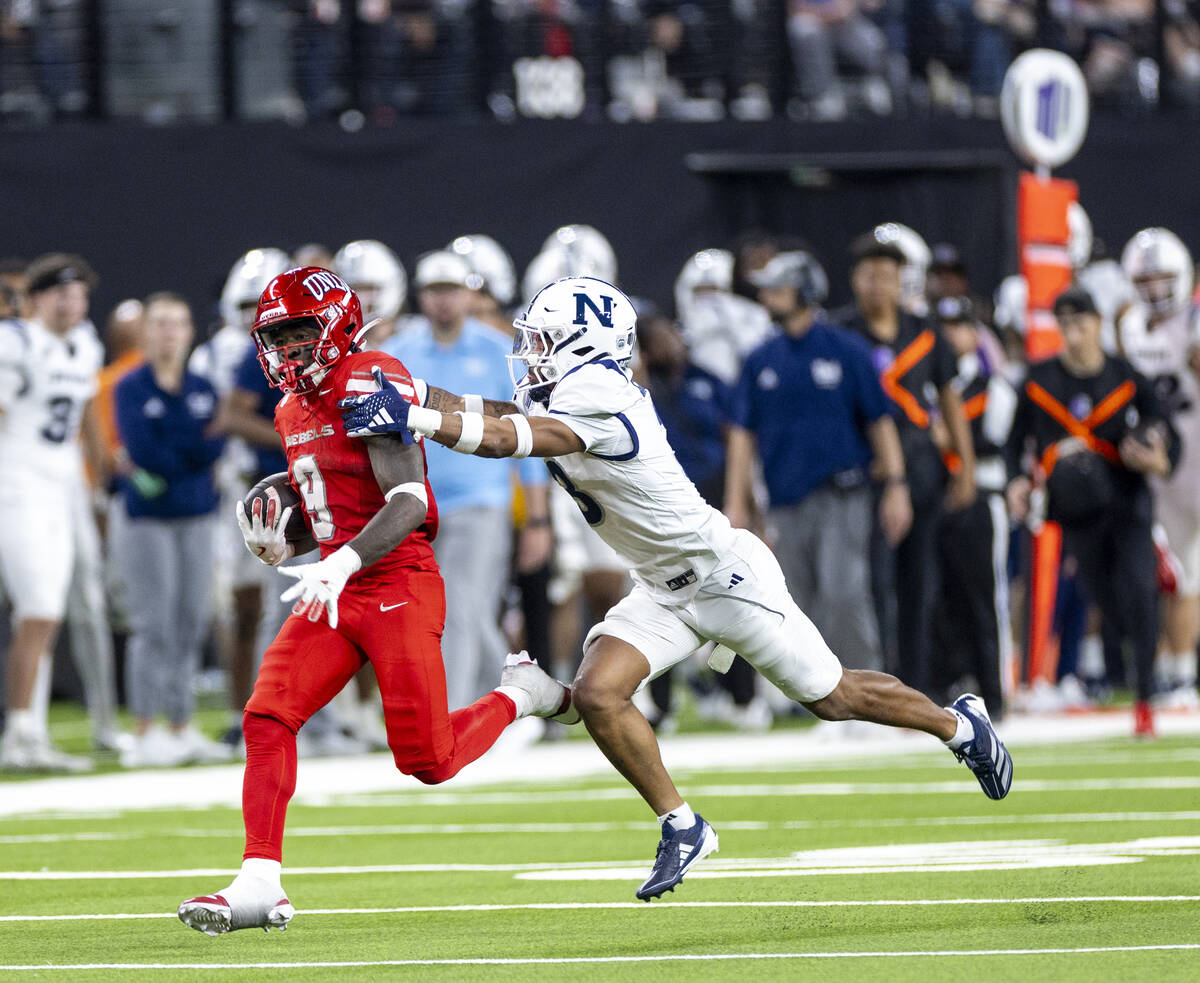 UNLV running back Jai'Den Thomas (9) attempts to outrun UNR cornerback Michael Coats Jr. (3) du ...