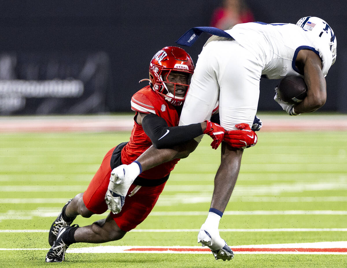 UNLV defensive back Jett Elad, left, tackles UNR wide receiver Jaden Smith, right, during the N ...