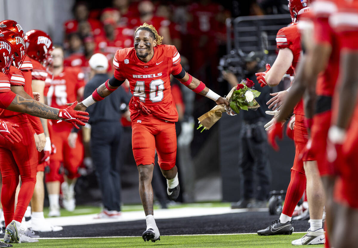 UNLV defensive back Daego Albert (40) high-fives teammates while running onto the field before ...