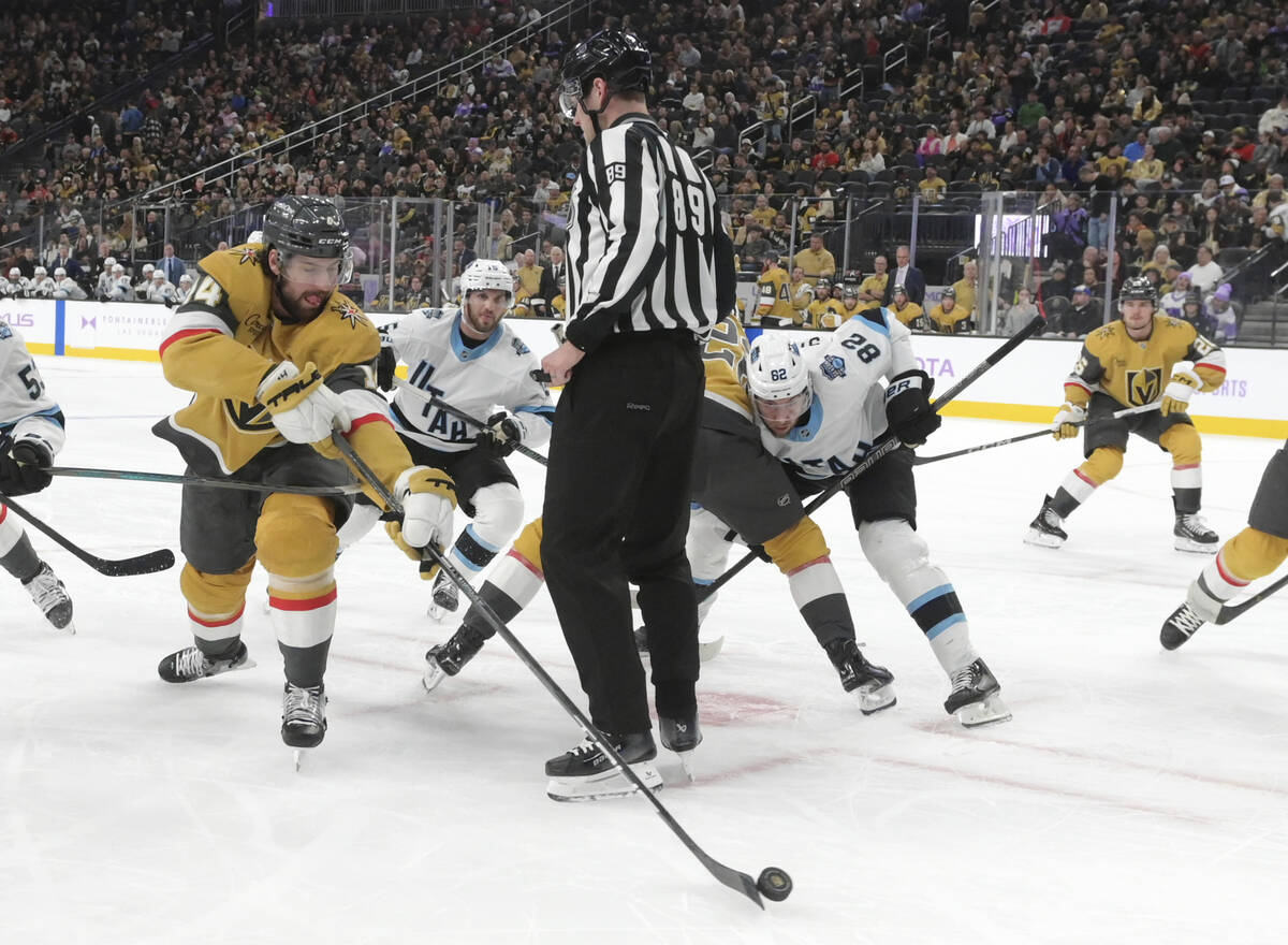 Vegas Golden Knights defenseman Nicolas Hague (14) tries to clear the puck around a referee dur ...