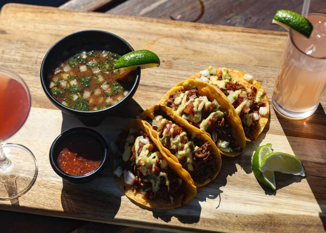 Birria tacos, slow cooked beef tacos with traditional dipping broth with cilantro, diced onions ...