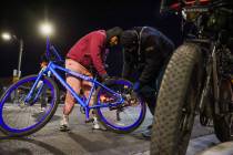 Thomas Ontivero, left, receives help filling up his tires from Marty Baier during a group bikin ...