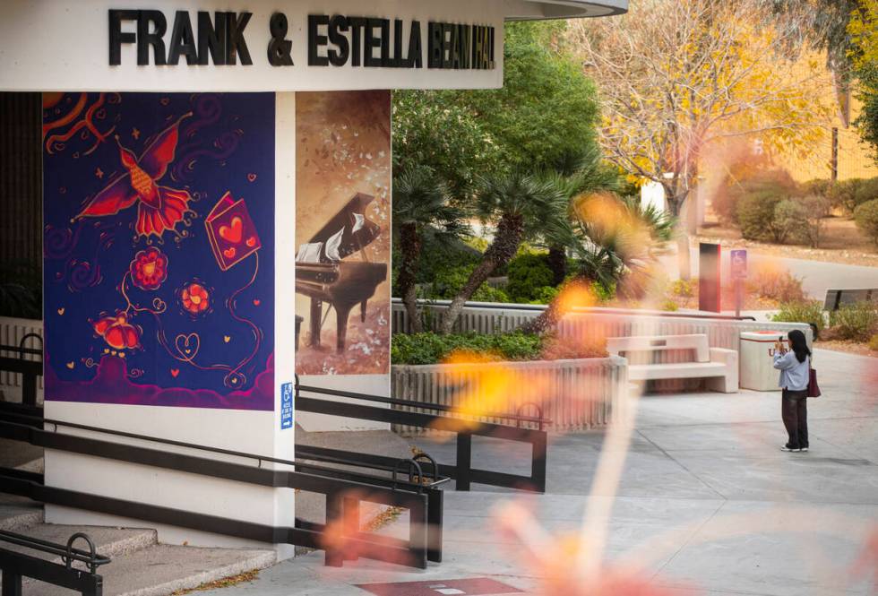 A woman takes a picture of murals honoring the victims of the Dec. 6 campus shooting are seen o ...